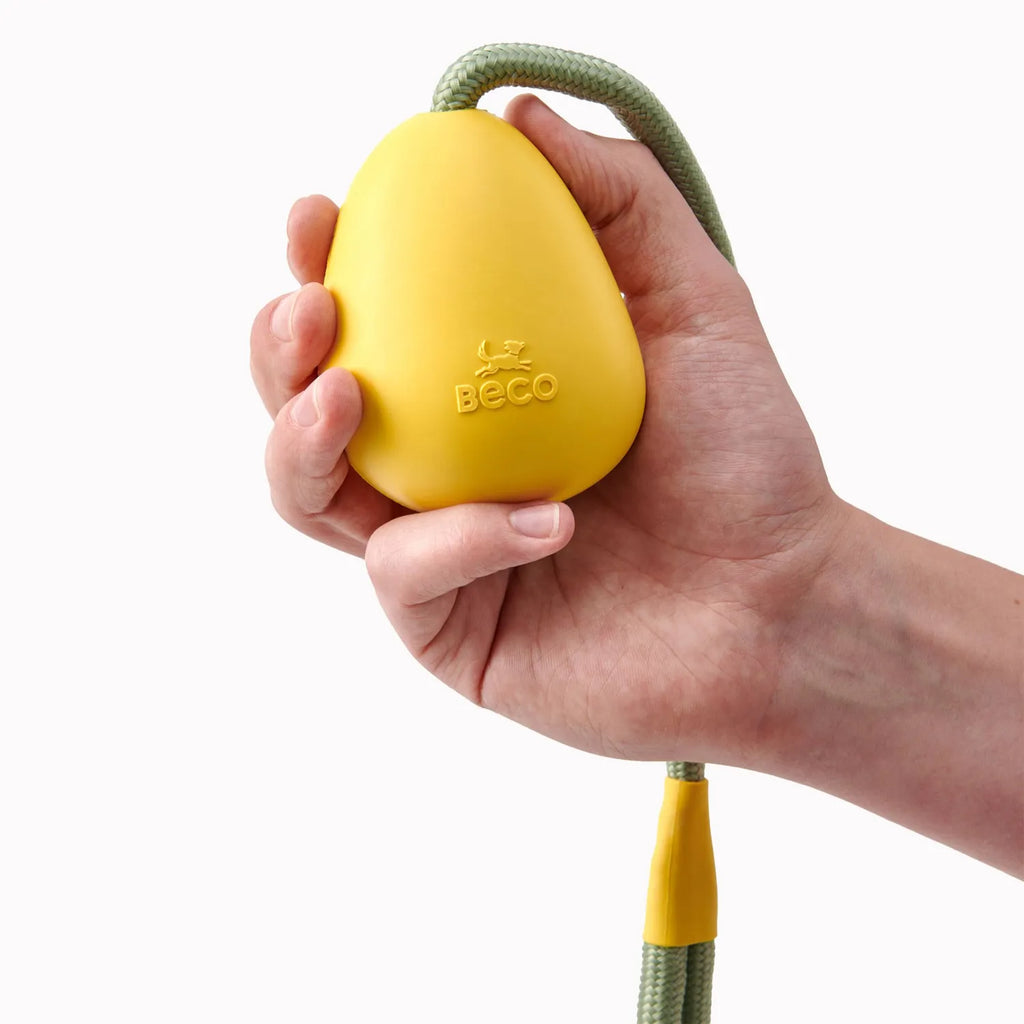 Beco Juguete Goma Natural Pebble para Lanzar, pelota amarilla con cuerda resistente para perros, diseño simple y material ecológico