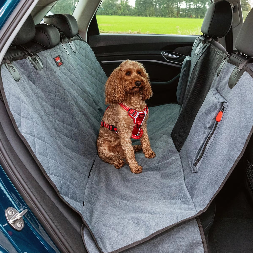 KONG Funda para Asiento Trasero y Hamaca para Auto instalada en un vehículo, protegiendo el asiento mientras un perro viaja cómodamente.