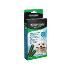 Naturalistic Dental Stick Menta para perros, caja verde y negra con sticks dentales verdes y perro blanco sosteniendo uno.