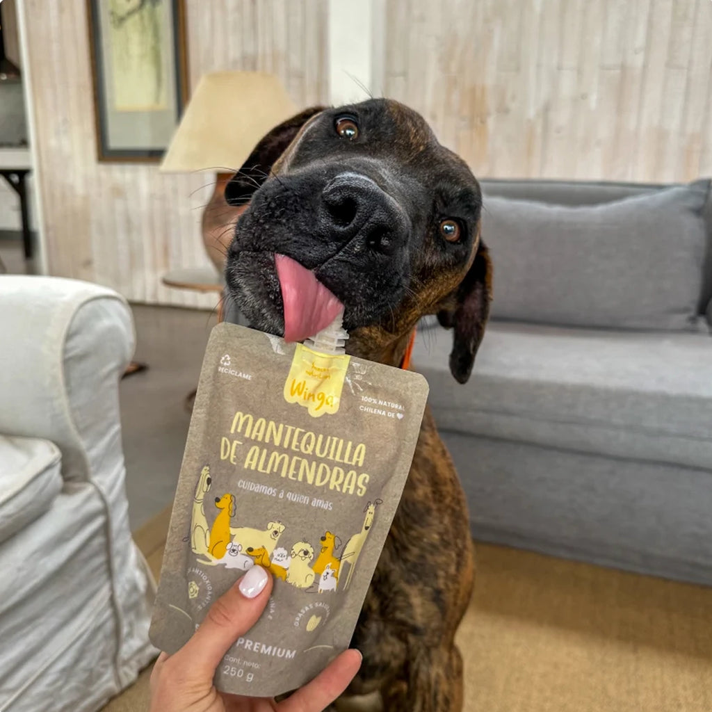 Winga Mantequilla de Almendras para Perros en pouch de 250 g con tapa dosificadora, envase natural e ilustraciones de perros.